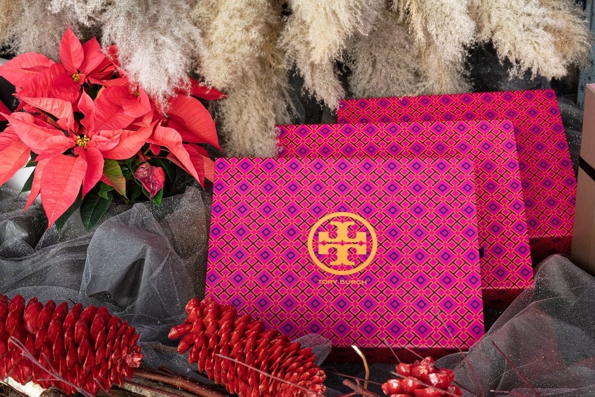 Beautiful boxes under a Christmas tree feature a colorful geometric pattern and the double-T logo of Tory Burch