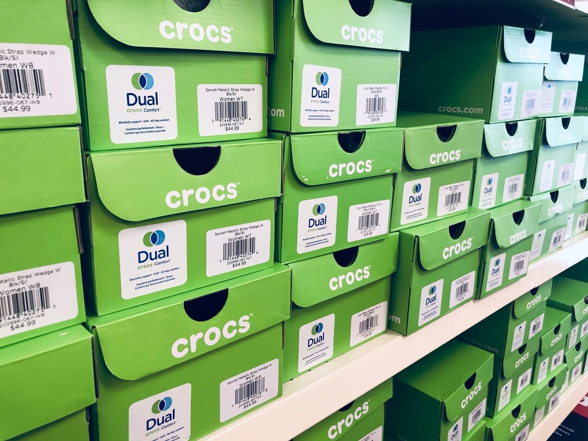 Crocs shoes in green, branded boxes at a shoe store