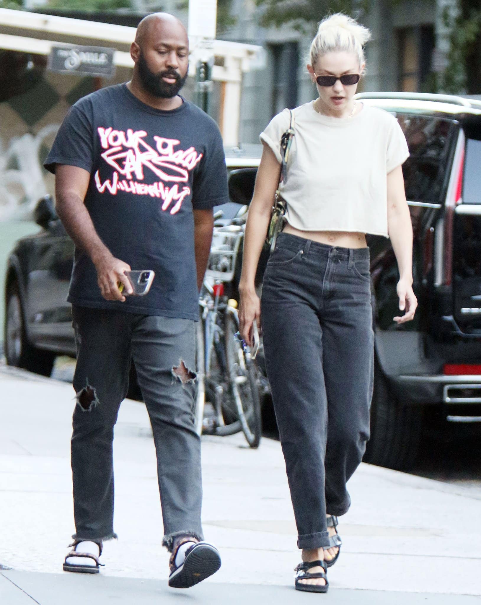 Gigi Hadid strolling around Soho in a cropped tee, a pair of black jeans, and Birkenstock x Valentino slides