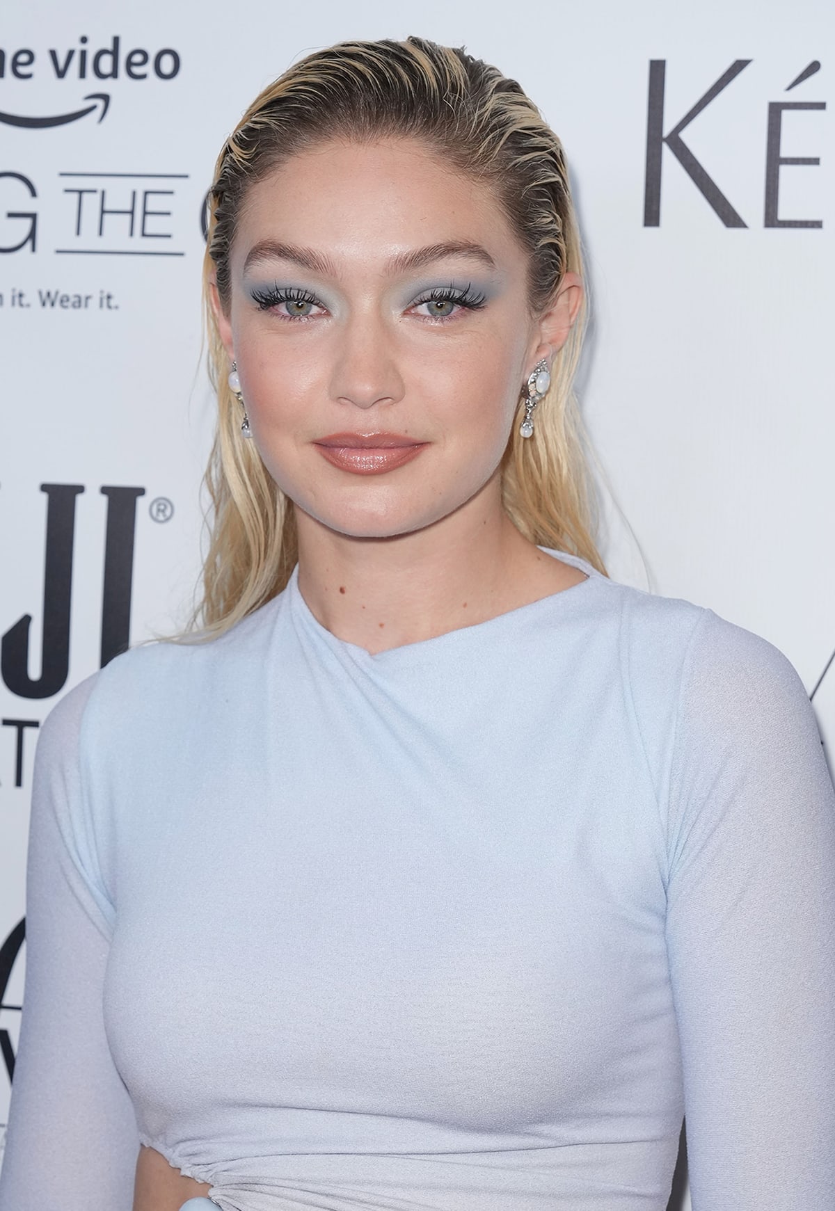 Gigi Hadid coordinates her blue eyeshadow with her outfit and wears a sultry wet-look hairstyle