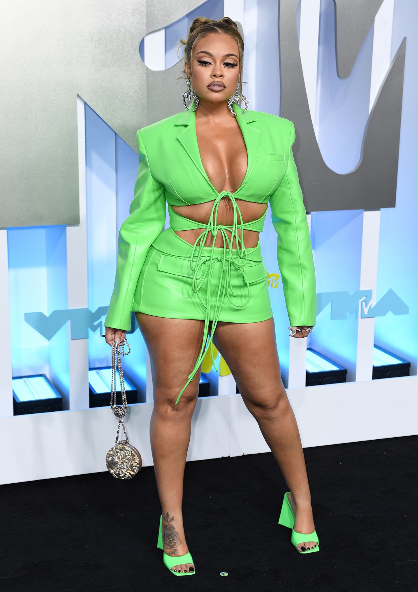 Latto puts on a busty display in a neon green Lado Bokuchava Spring/Summer 2022 plunging blazer and mini skirt