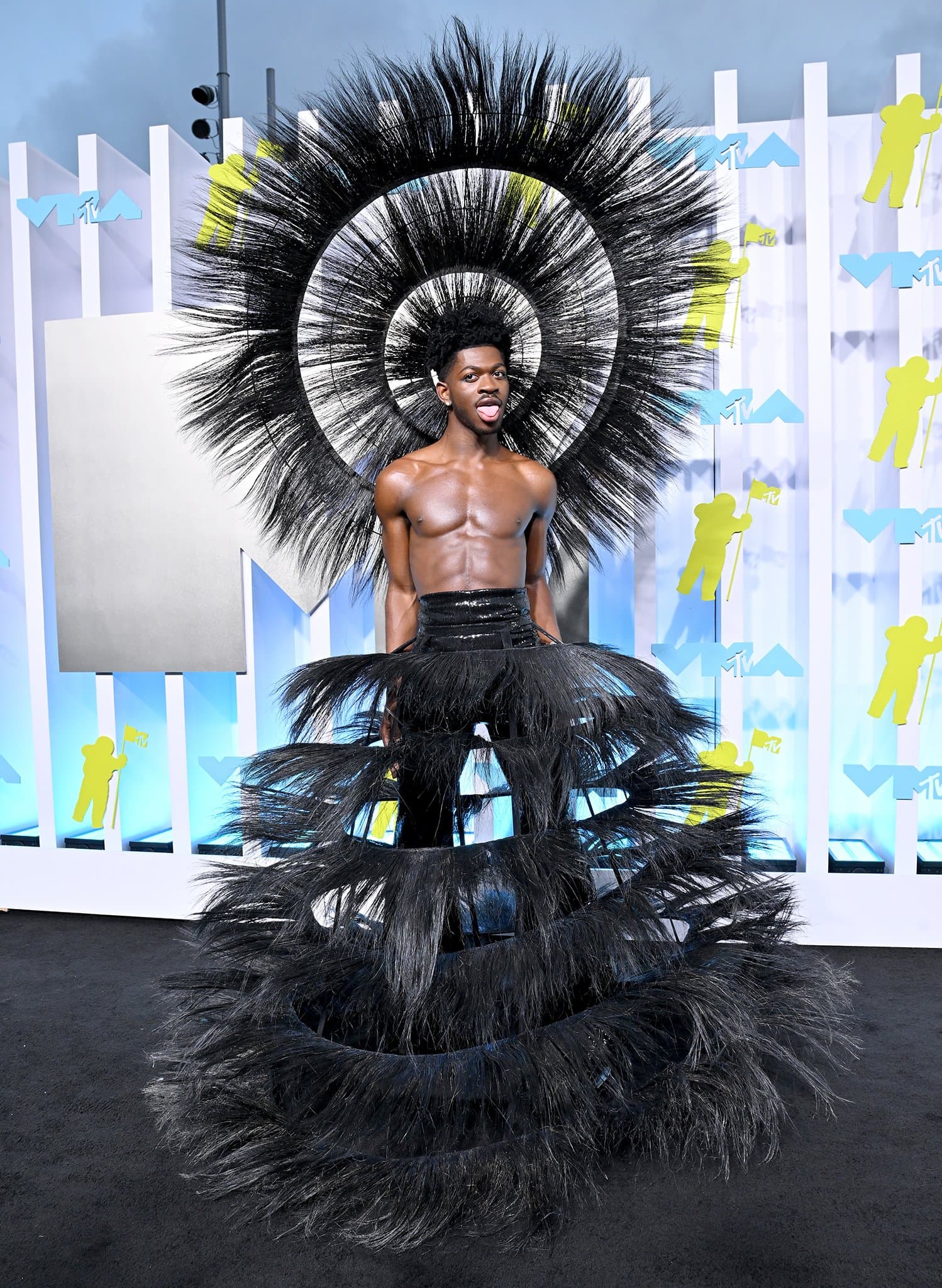 Lil Nas X slays in a Harris Reed upcycled feathered skirt and a matching headpiece