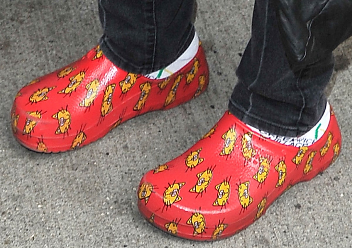 Whoopi Goldberg wears white socks with red cat-print Crocs sandals