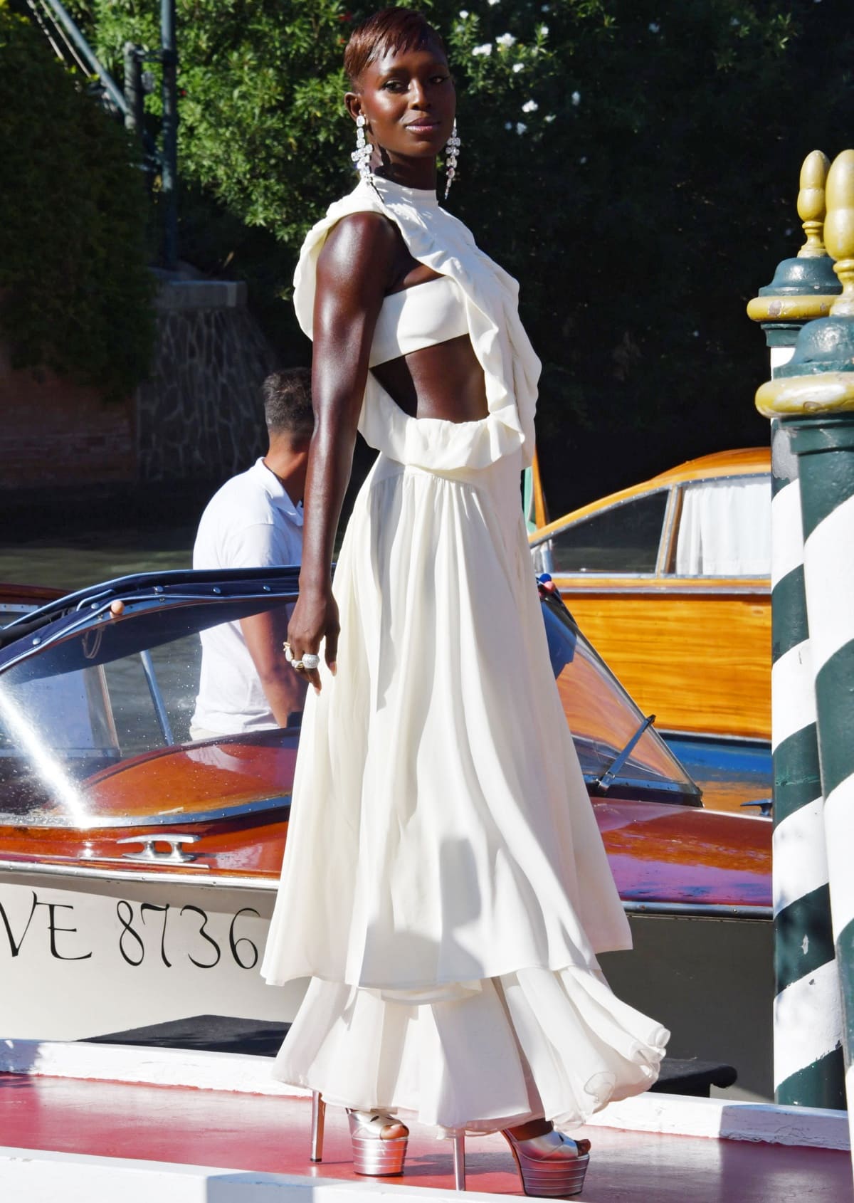 Jodie Turner-Smith looking chic in a white Harbison dress layered over matching white pants and styled with silver platform heels