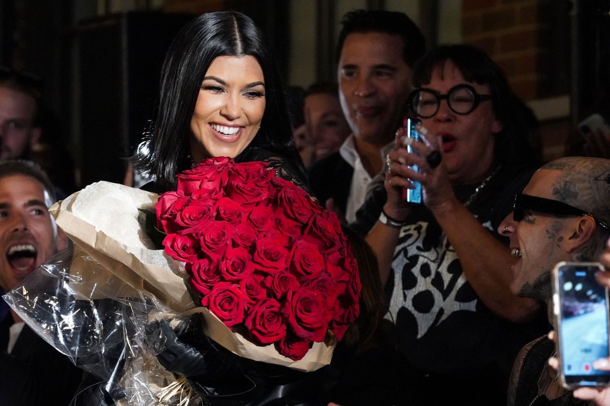 Kourtney Kardashian with husband Travis Barker and a bouquet of roses at New York Fashion Week