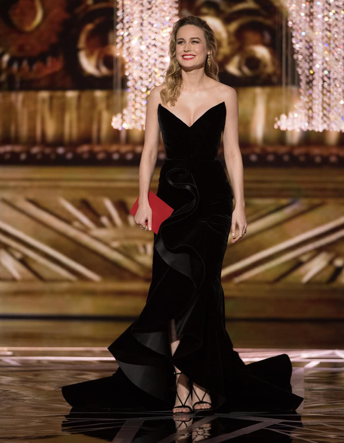 Brie Larson presents during the 89th Oscars in a sculpted black Oscar de la Renta velvet gown paired with custom strappy Aquazzura “Casanova” sandals