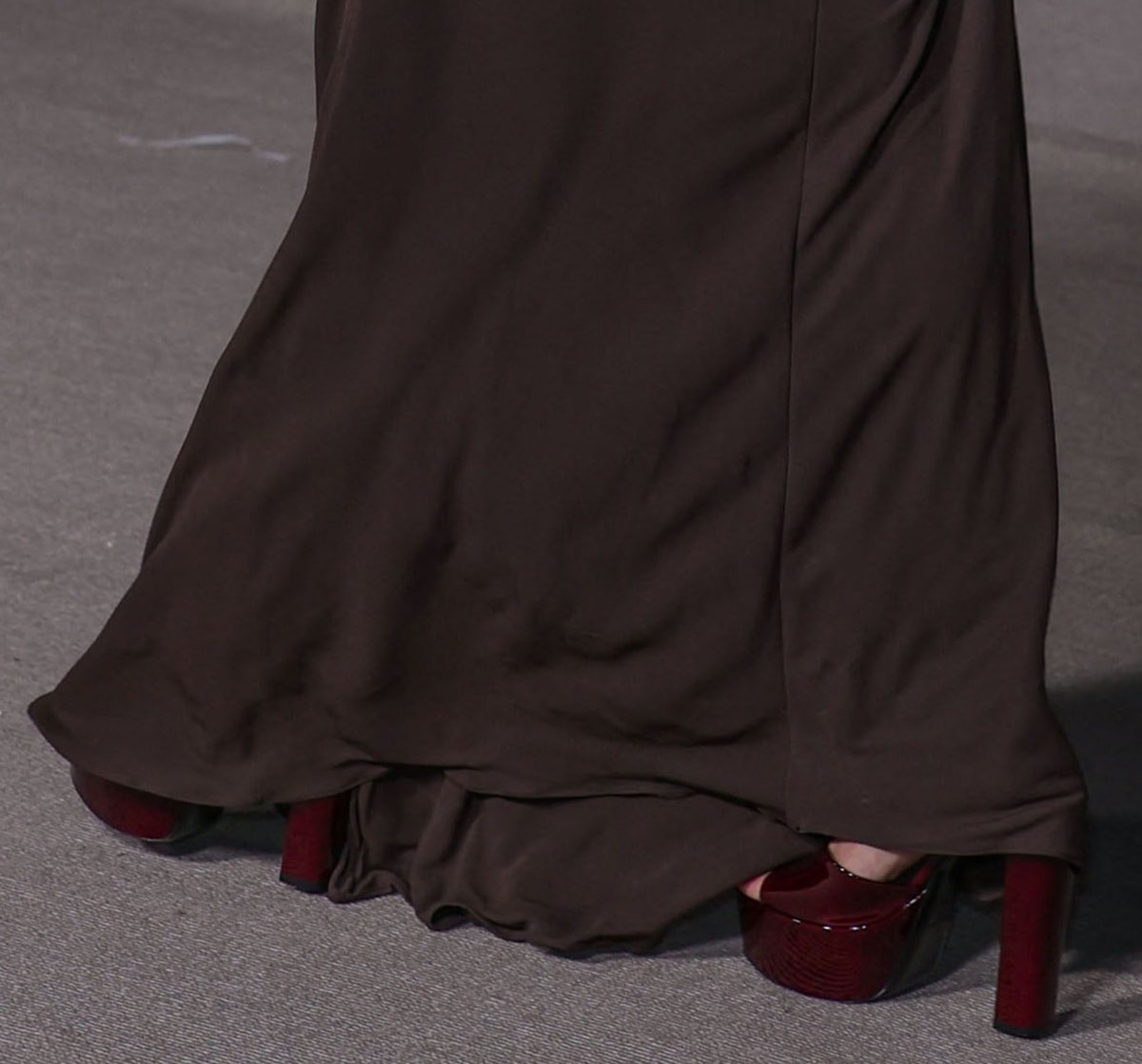 Hailey Bieber pairs her brown dress with burgundy patent platform sandals by Saint Laurent