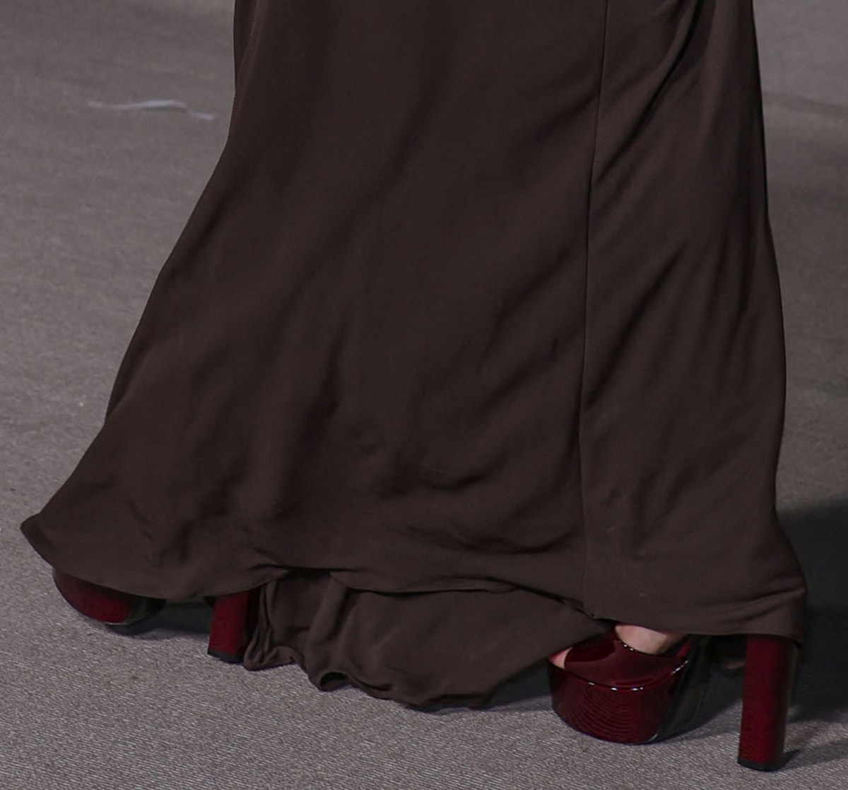 Hailey Bieber pairs her brown dress with burgundy patent platform sandals by Saint Laurent