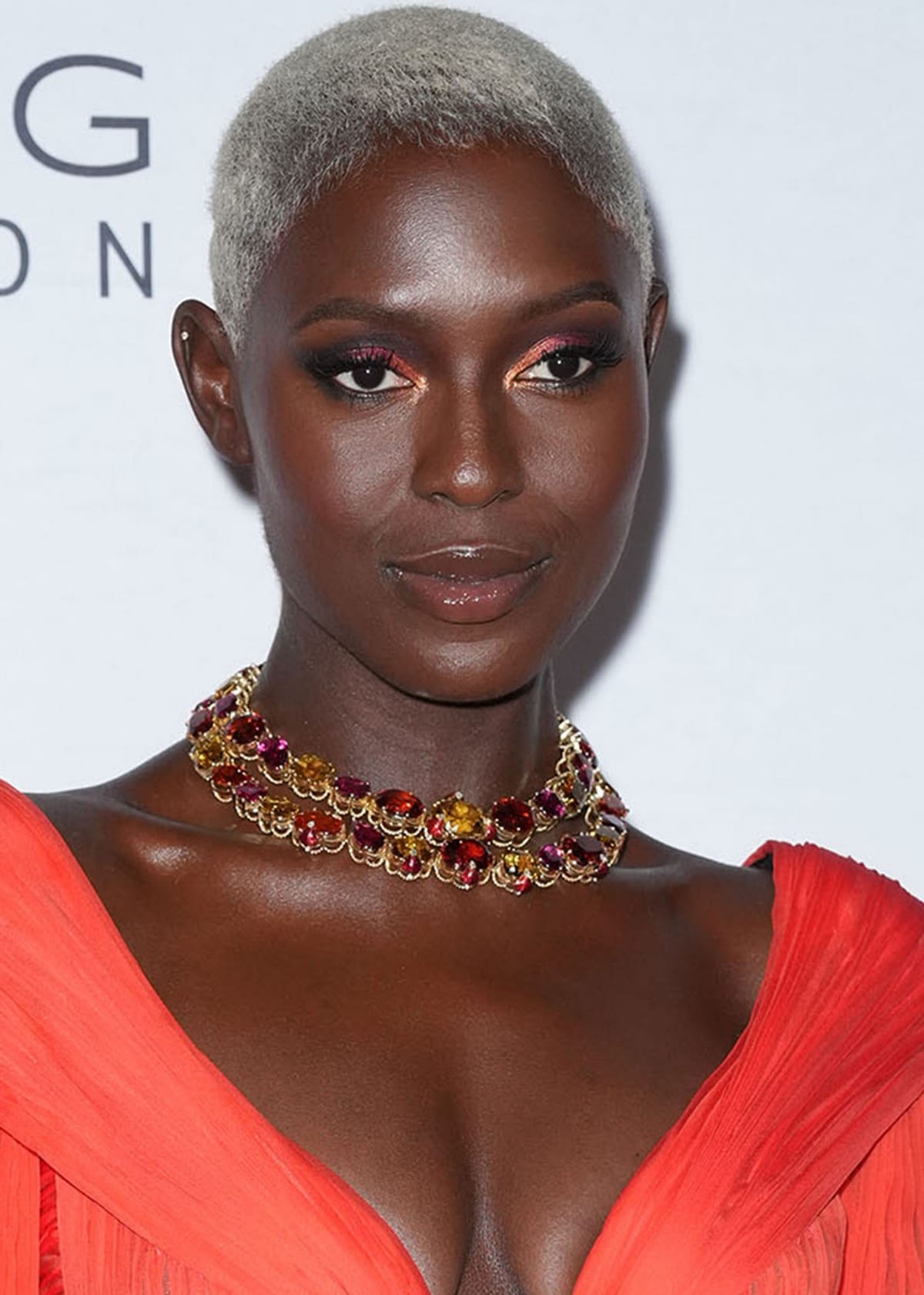 Jodie Turner-Smith rocking a blonde buzz cut, shimmery eye makeup, and a ruby necklace from Bulgari