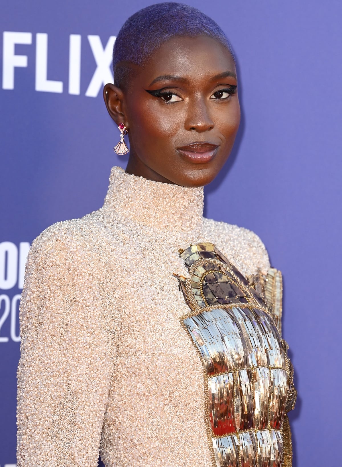 Jodie Turner-Smith styled her look with a purple buzz cut, winged eyeliner, and Bulgari jewels