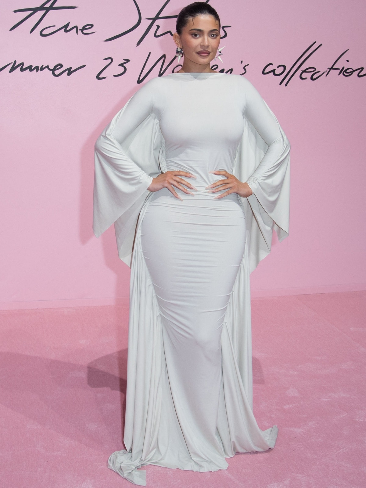 Kylie Jenner wearing a white Acne Studios Spring 2023 floor-length dress at the brand’s runway presentation during Paris Fashion Week