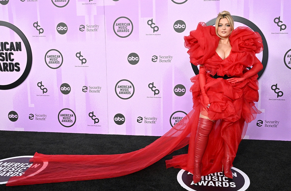 Bebe Rexha flaunts her boobs in a red tulle gown by Buerlangma with matching thigh-high red boots by Le Silla