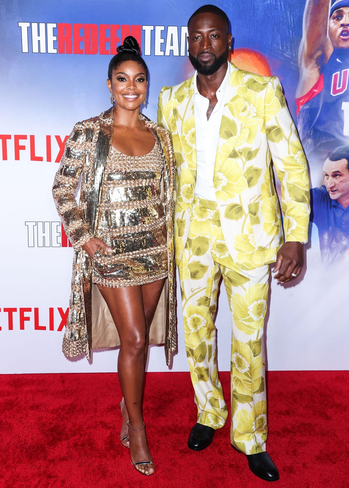 Gabrielle Union dazzles in a shimmering gold mini dress and matching coat, while Dwyane Wade stuns in a bold yellow floral suit, making a statement at the premiere of The Redeem Team