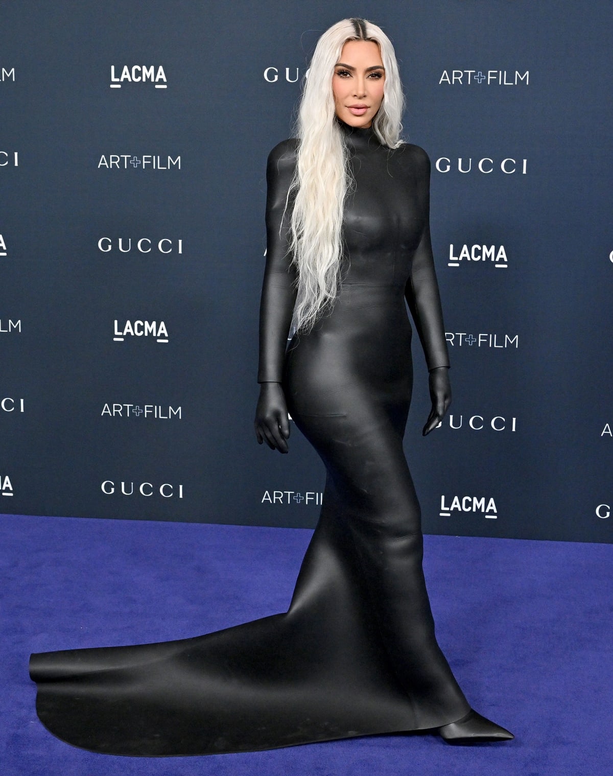Kim Kardashian in a fitted black Balenciaga dress featuring a high neck and sleeves that included gloves