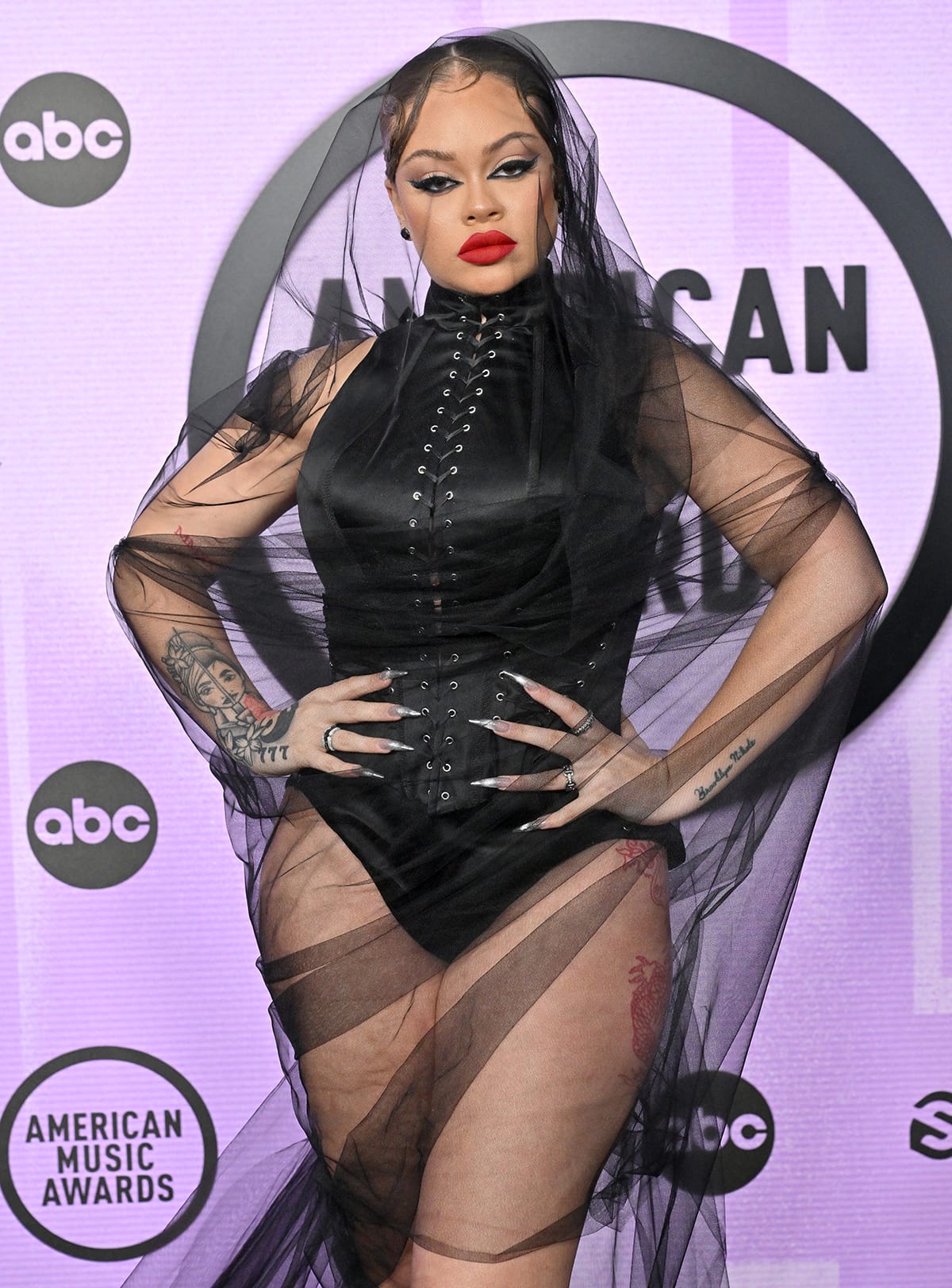 Latto's BDSM outfit features a black mesh overlay, which she paired with Femme LA clear pumps