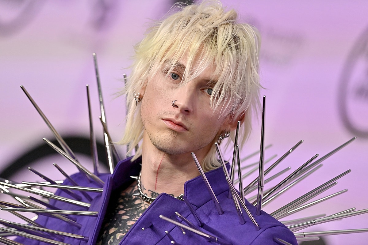 Machine Gun Kelly styles his sharp outfit with a matching spiky necklace and chunky boots