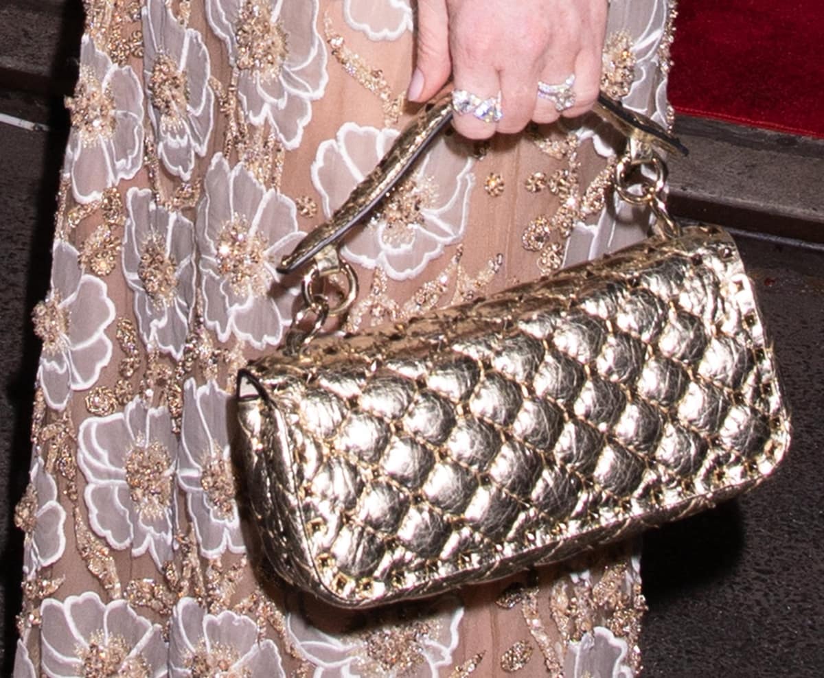 Lindsay Lohan totes a quilted metallic lambskin Valentino Garavani Rockstud Spike bag that is embellished with small stud