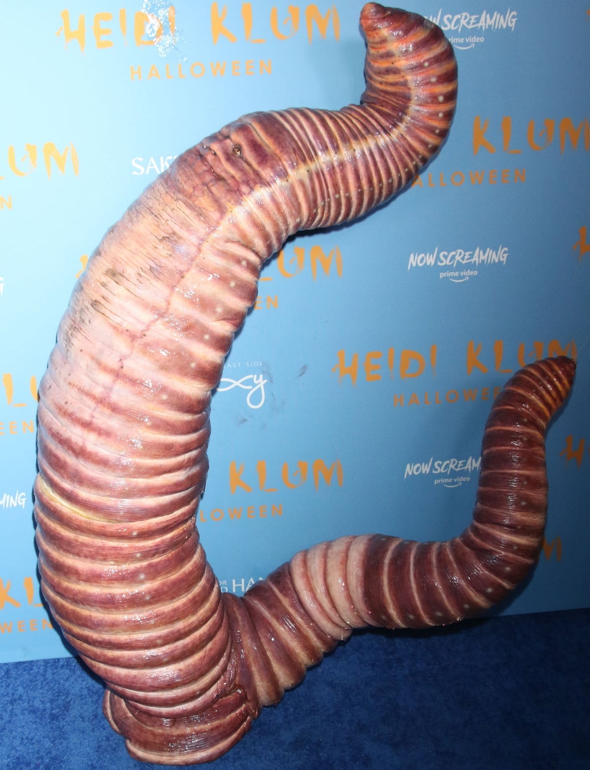 Heidi Klum hamming it up for the cameras while dressed as a giant rain worm for Halloween