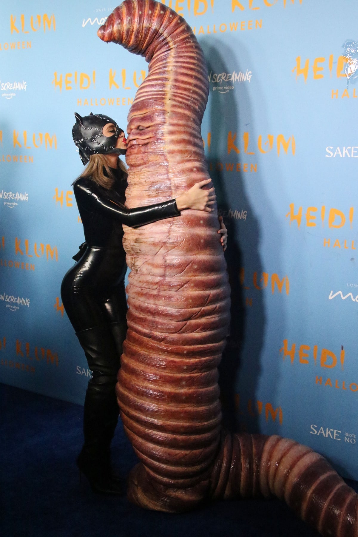 Leni Klum as Catwoman giving her mom a kiss on the blue carpet at Heidi Klum’s 21st Annual Halloween Party