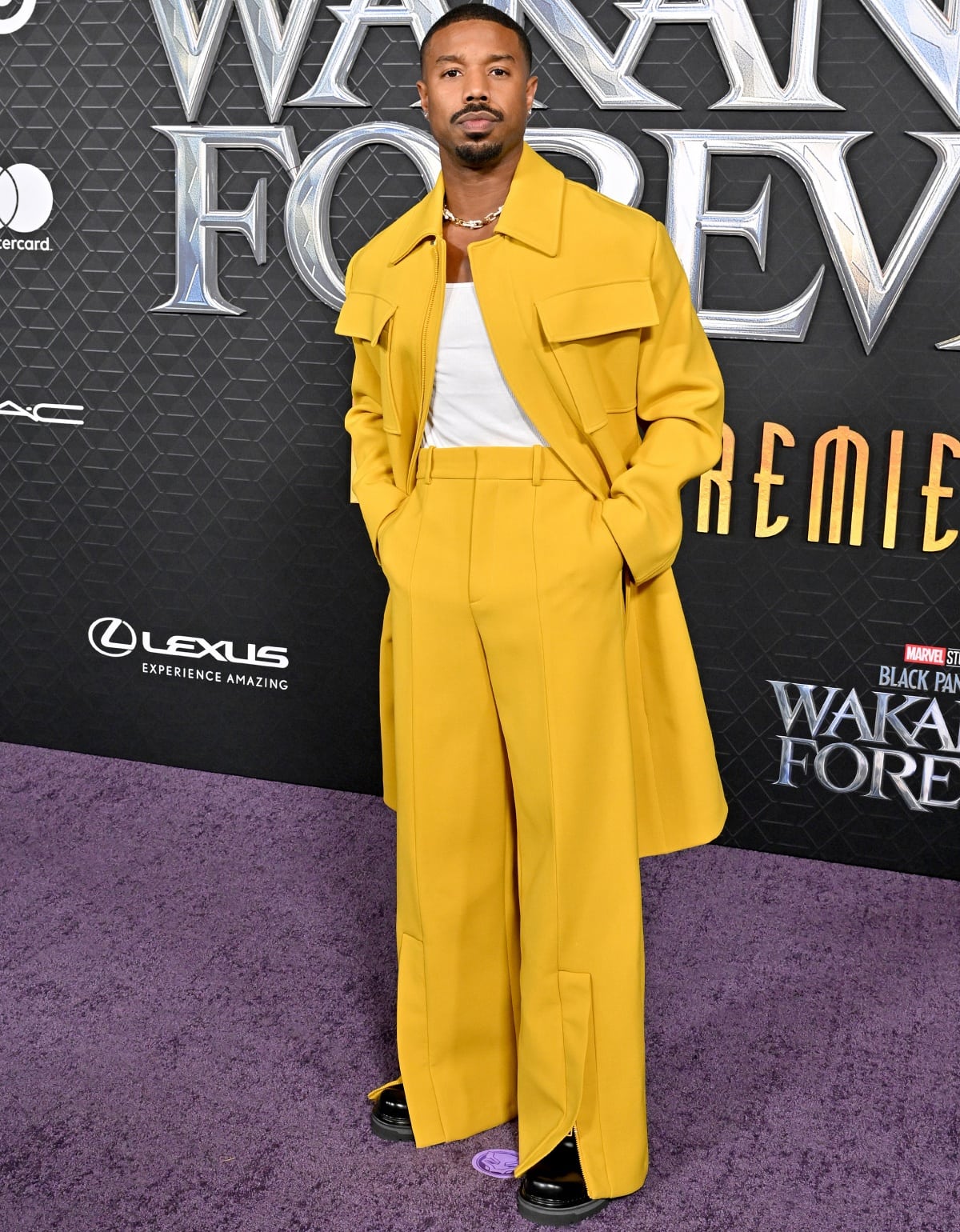Michael B. Jordan wearing a Louis Vuitton Spring 2023 yellow suit with an Intimissimi tank top and black dress shoes