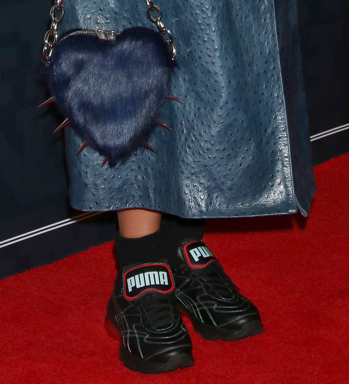 Dua Lipa carries a furry blue heart-shaped bag and completes her look with the Puma x Dua Lipa Cell Dome King sneakers