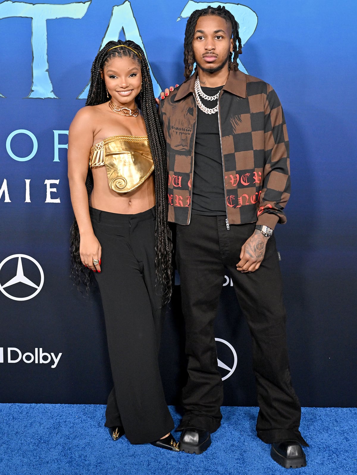 Halle Bailey poses with rapper boyfriend DDG, who wears a checkered jacket with chunky square-toe shoes