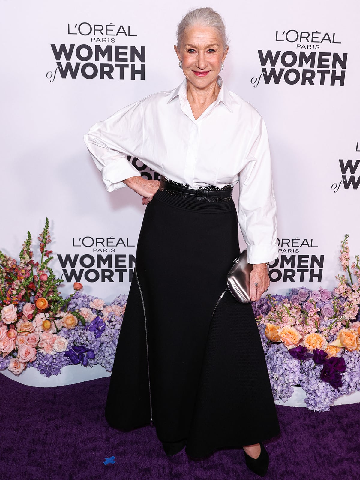 Helen Mirren opts for a classy monochrome ensemble by Alaia, featuring a white shirt and a black midi skirt