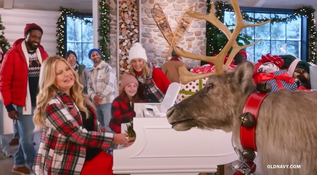 Jennifer Coolidge smiles as she gets ready to feed asparagus to a reindeer