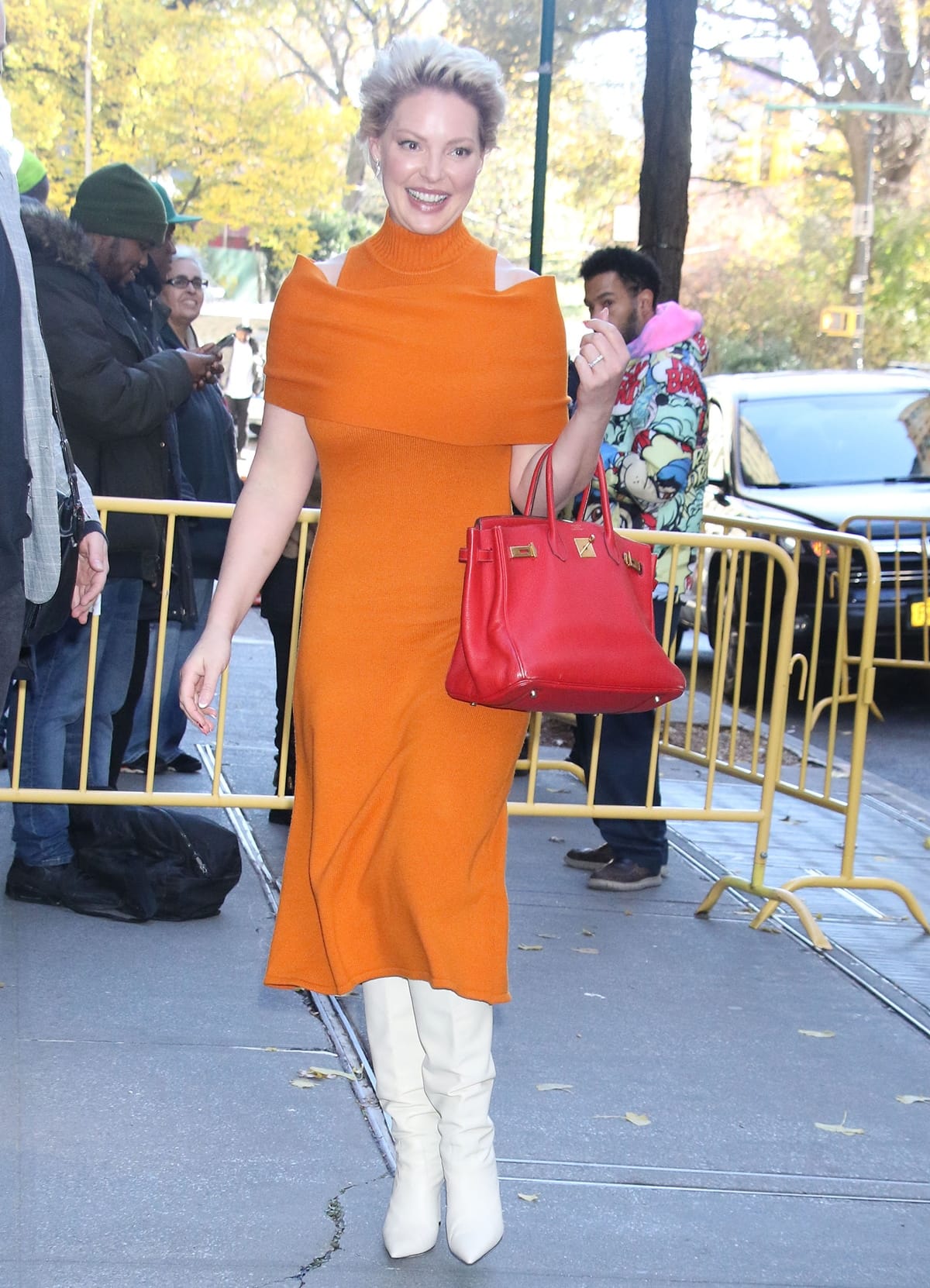 Katherine Heigl wears an orange Halston Ensley wool & cashmere midi-dress on November 28, 2022, in New York City