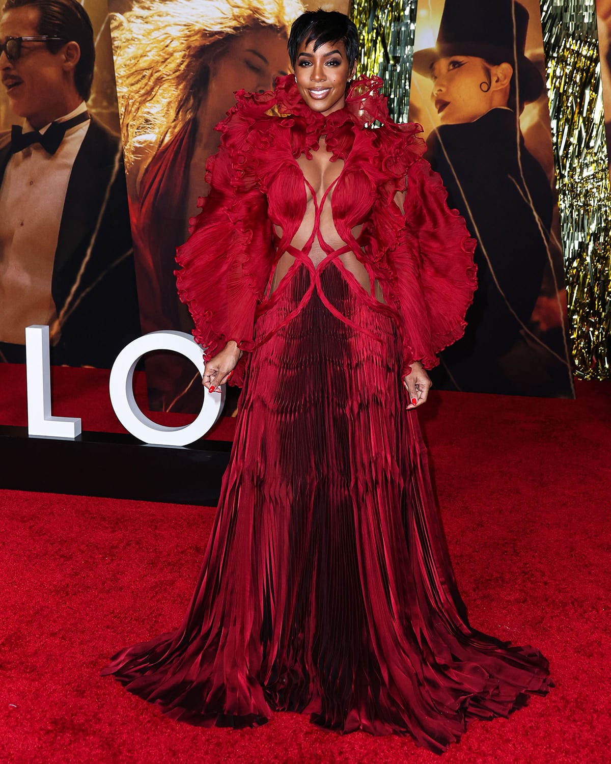 Kelly Rowland flaunts her boobs and abs in a red ruffled cutout gown by Iris Van Herpen