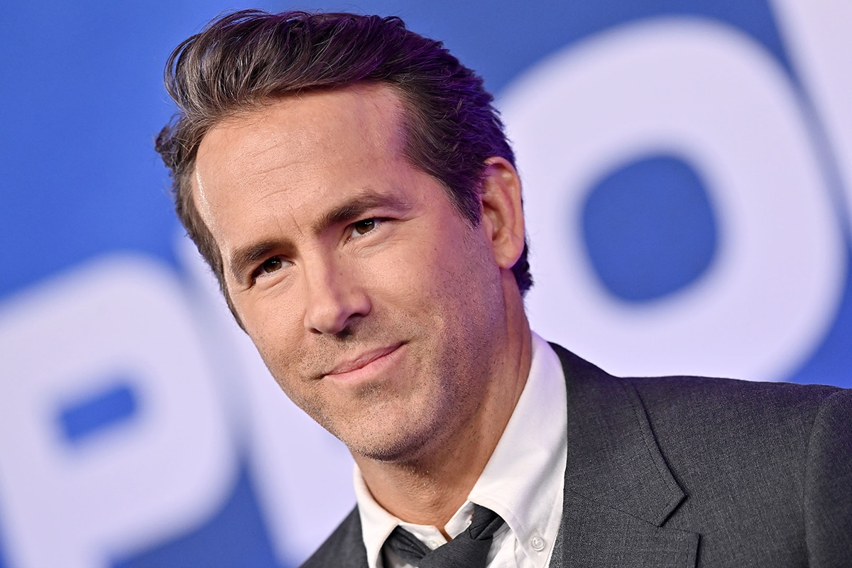 Ryan Reynolds wears a side-parted brushed-up hairstyle and accentuates his features with minimal makeup