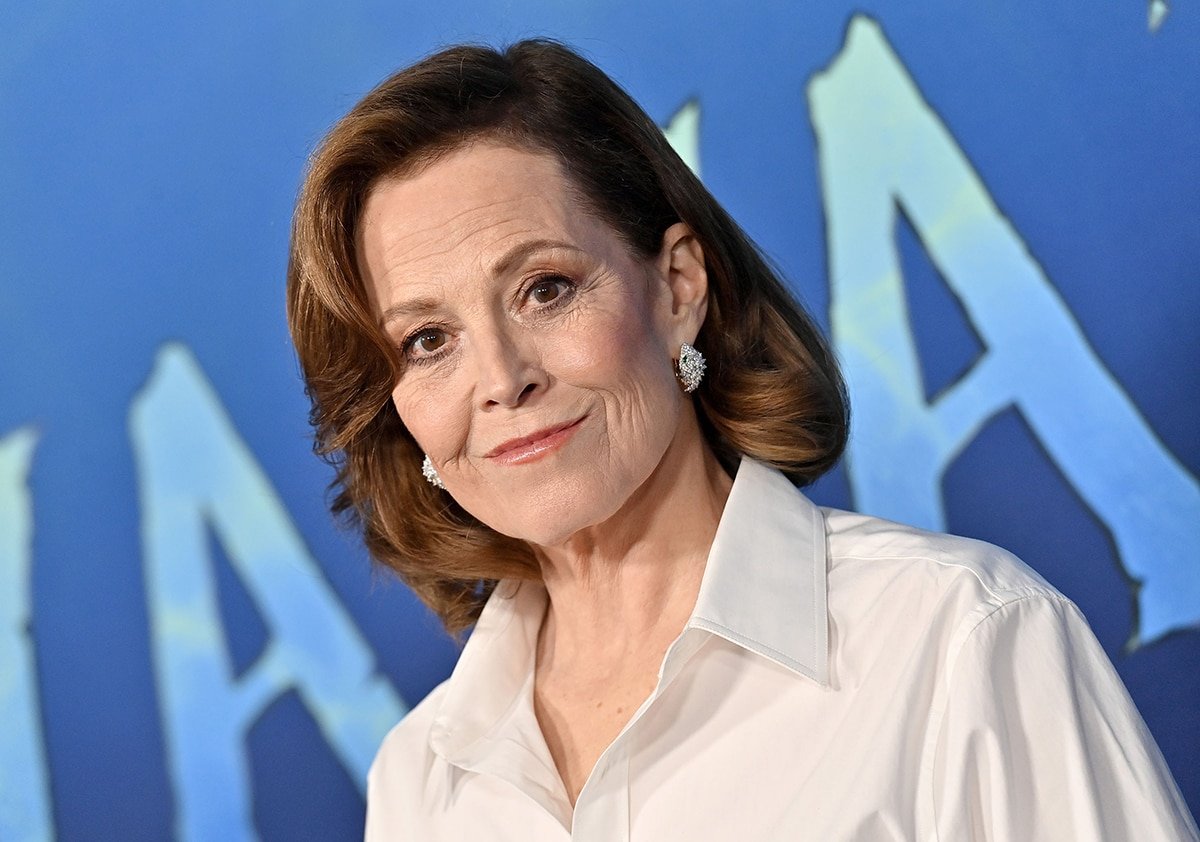 Sigourney Weaver styles her look with diamond earrings, a wavy hairstyle, and soft pink makeup