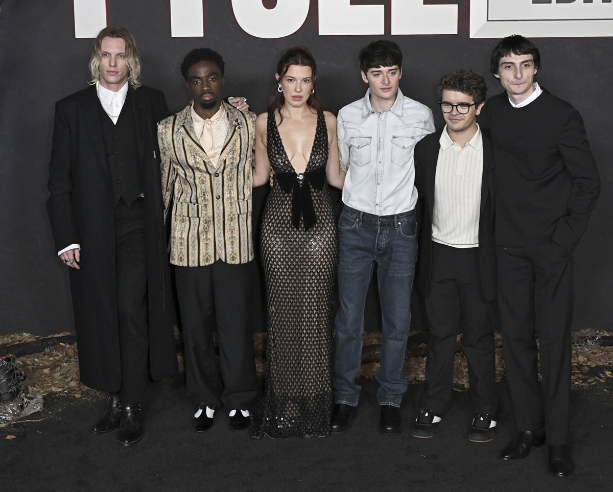 Jamie Campbell Bower, Caleb McLaughlin, Millie Bobby Brown, Noah Schnapp, Gaten Matarazzo, and Finn Wolfhard coordinate sleek black-carpet looks—mixing tailored suiting, standout textures, and polished dress shoes—at Netflix’s Fall Edit “Stranger Things” event at the TUDUM Theater on November 8, 2025, in Hollywood, California