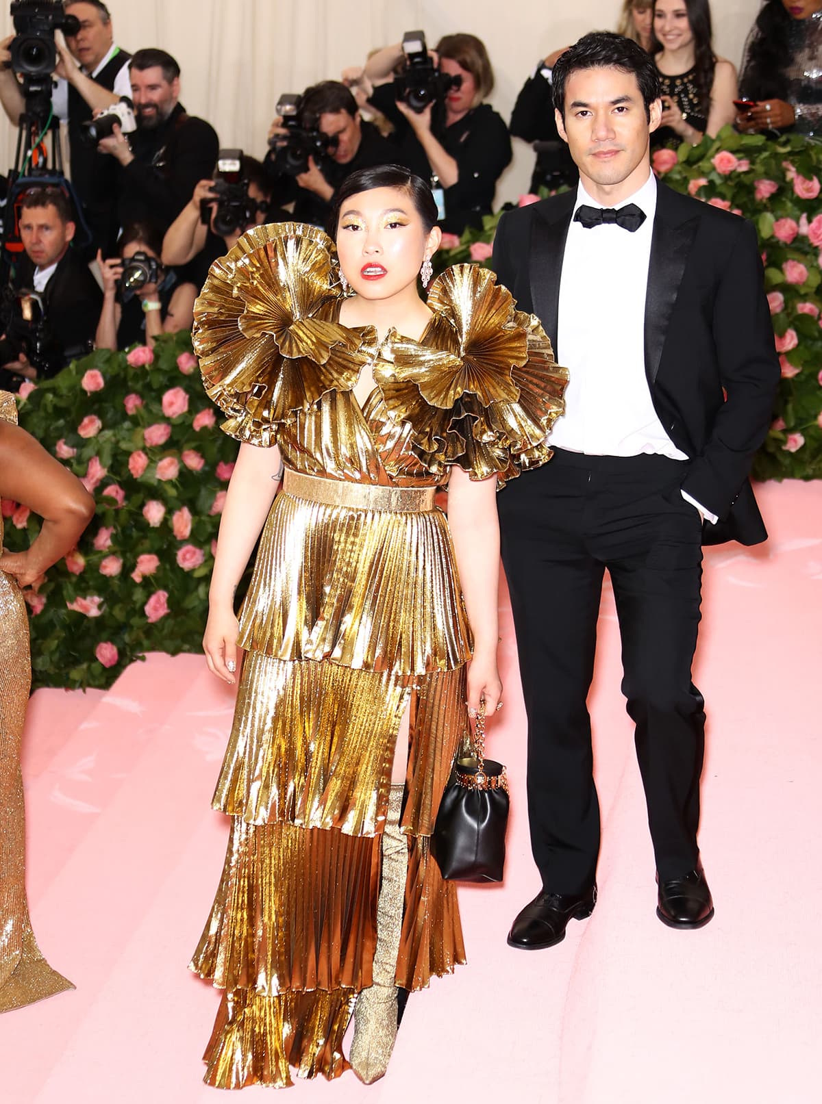 Awkwafina wearing a gold pleated Altuzarra gown at the 2019 Met Gala