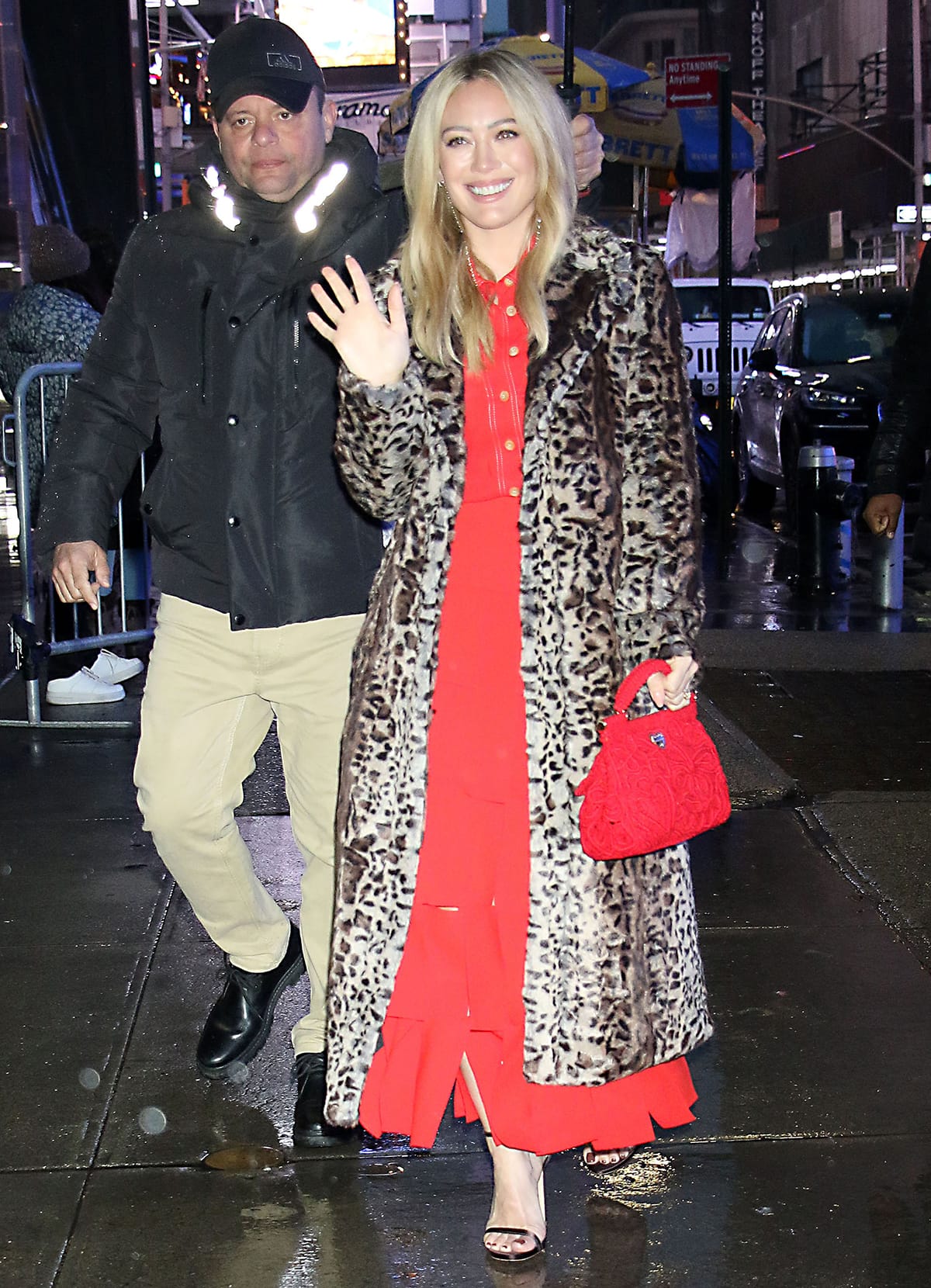 Hilary Duff bundles up in a leopard coat worn over her red dress