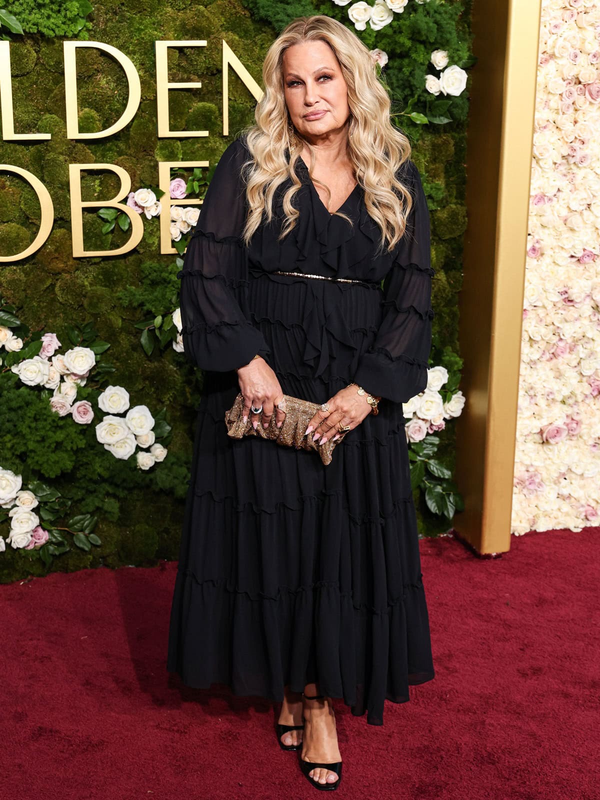 Jennifer Coolidge attends the 82nd Annual Golden Globe Awards in a tiered black gown paired with black open-toe stiletto heels and a glittery gold clutch at The Beverly Hilton on January 5, 2025, in Beverly Hills, California
