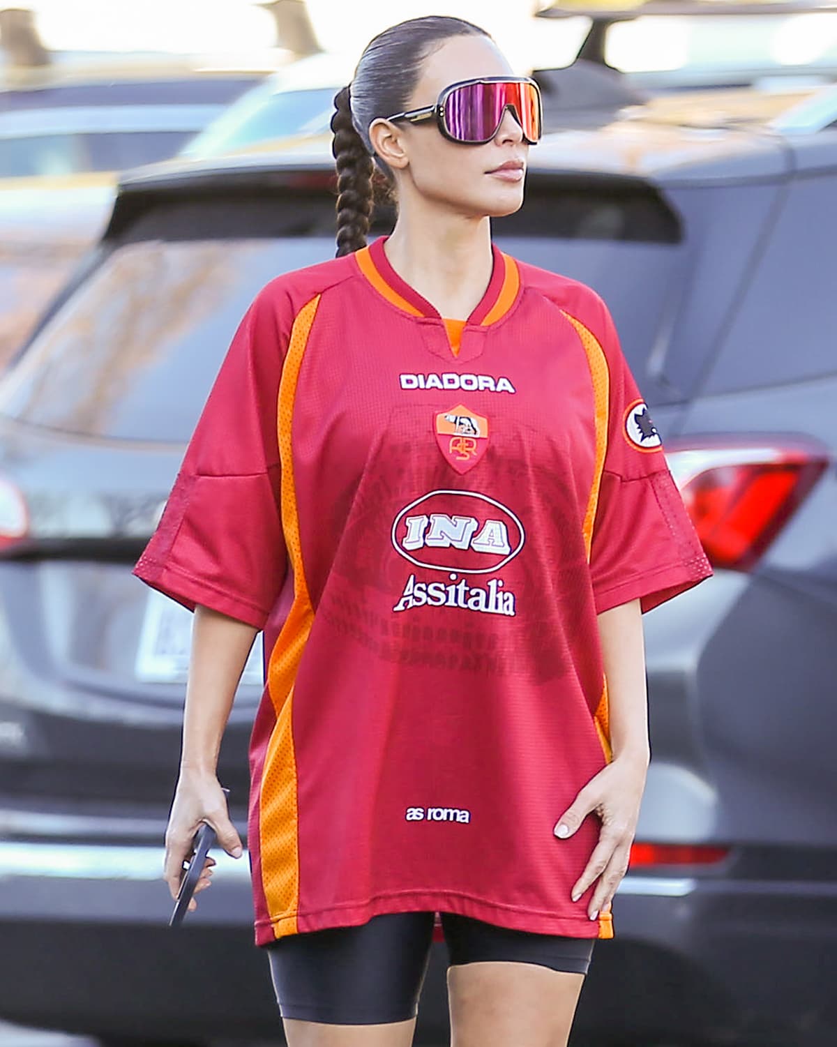 Kim Kardashian hides her eyes behind Carrera's Epica 0Uc/W3 sunglasses and wears her hair in a braided ponytail