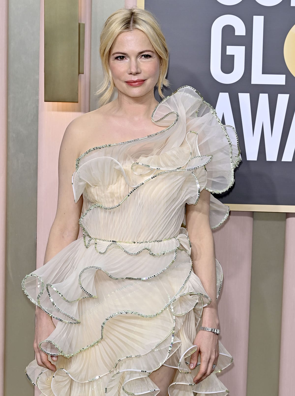 Michelle Williams keeps her beauty look romantic with an elegant updo and rosy makeup using Chanel cosmetics