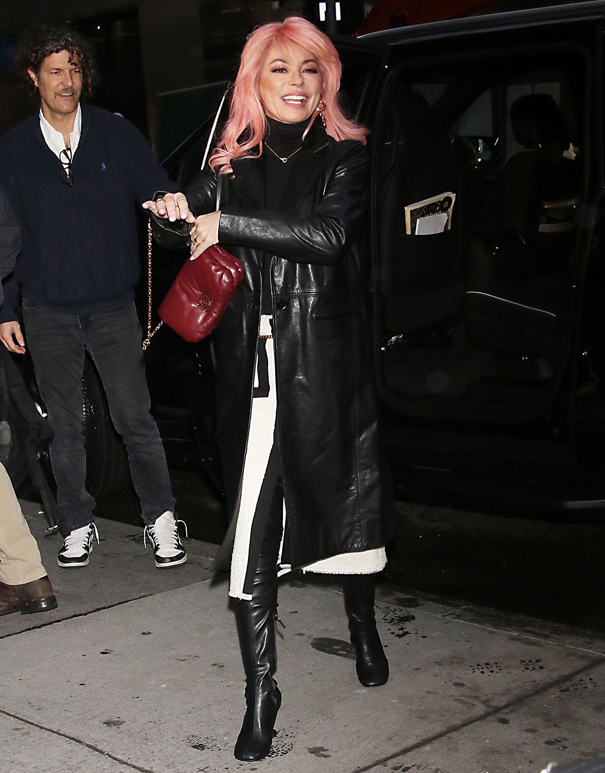 A pink-haired Shania Twain sporting a Maje leather coat with a black turtleneck top and a pair of thigh-high boots on her way to the Today Show studios on January 5, 2023