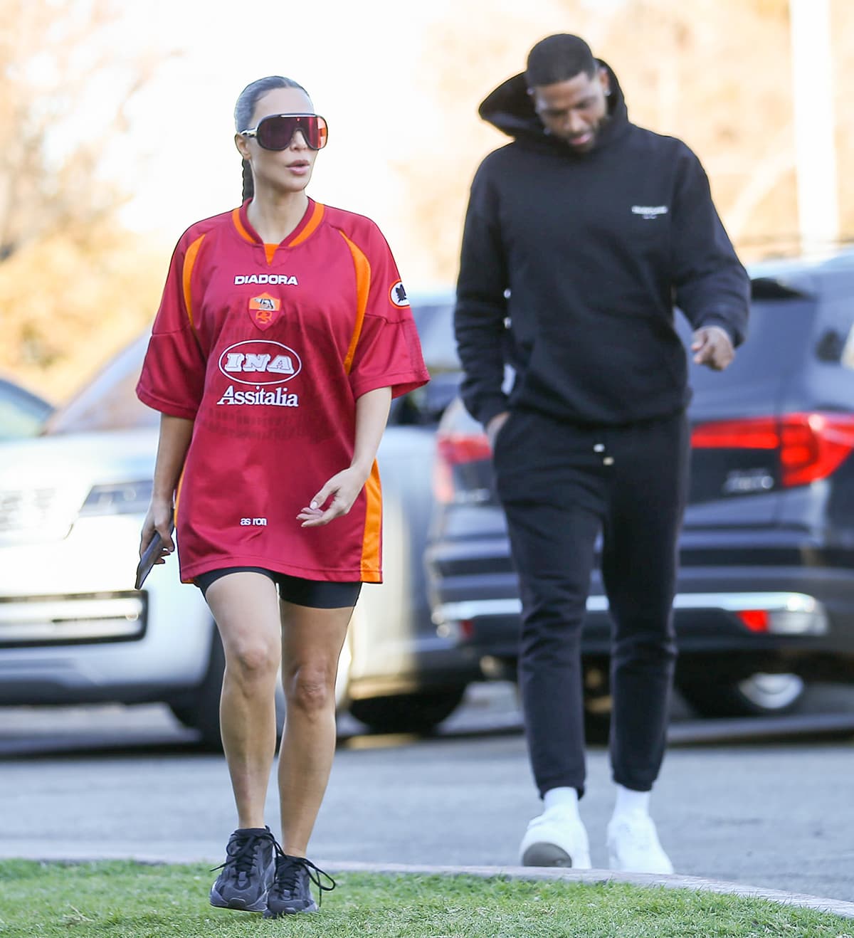 Tristan Thompson opts for a sporty attire with a black hooded sweatshirt, matching sweatpants, white crew socks, and a pair of white sneakers