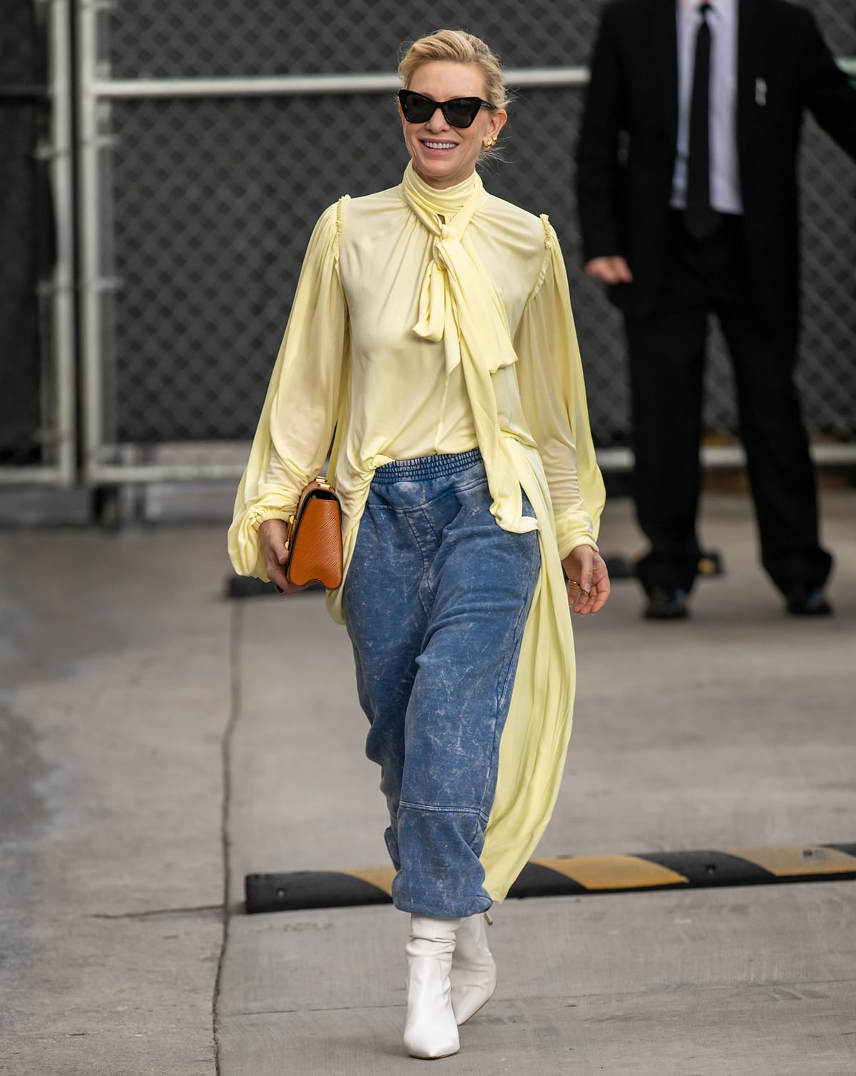 Cate Blanchett visits Jimmy Kimmel Live! in a pale yellow Loewe asymmetric dress with stone-washed jogger pants on February 13, 2023