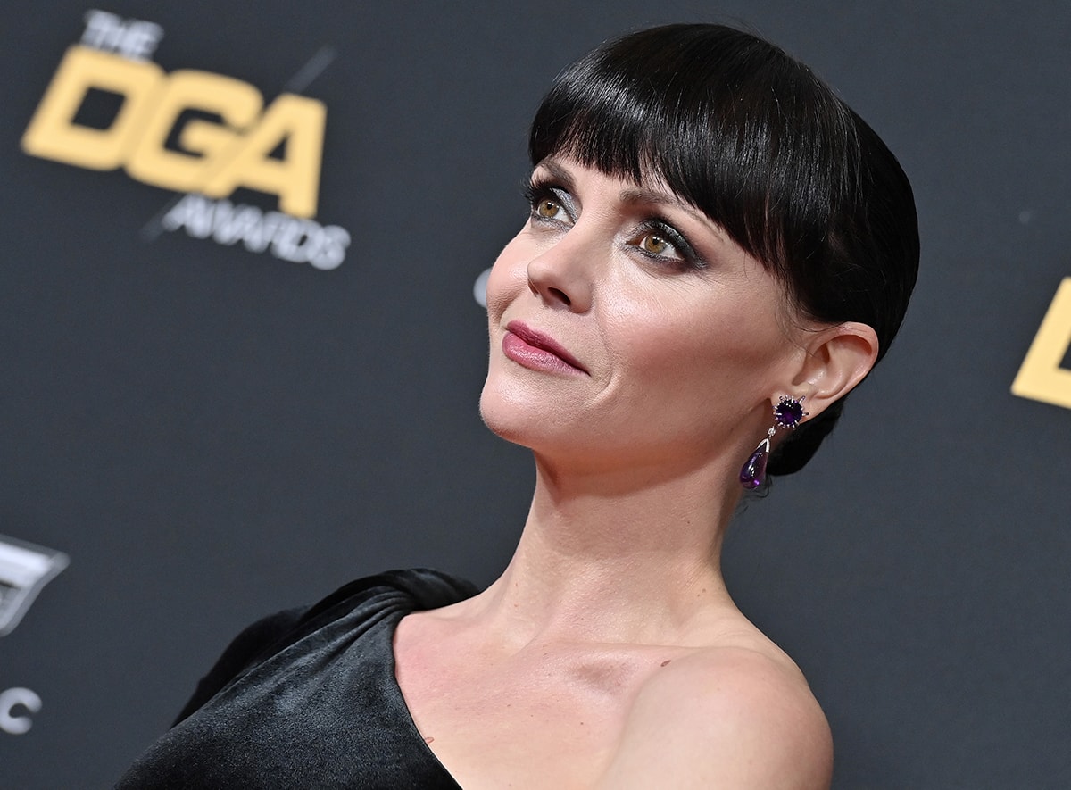 Christina Ricci continues with the dark glamour theme of her look by wearing dramatic smokey eye-makeup, with her tresses in a neat bun with full bangs