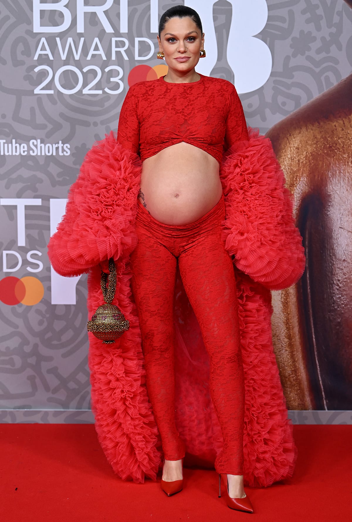 Jessie J showcases her bare baby bump in a floral lace crop top and matching leggings by Brielle at the 2023 BRIT Awards at London's O2 Arena on February 11, 2023