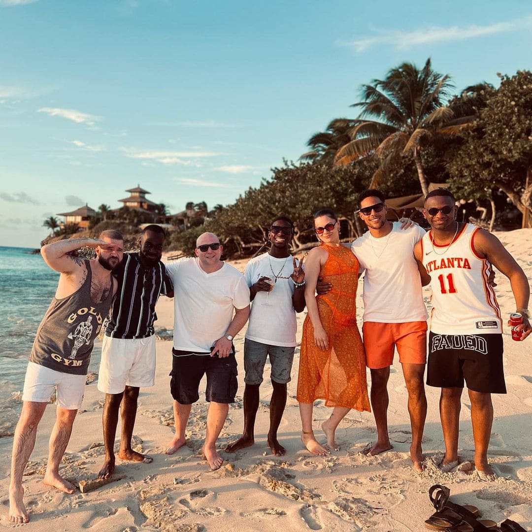 Jessie J with boyfriend Chanan Safir Colman, wearing a white tee and orange shorts, at a beach in March 2022