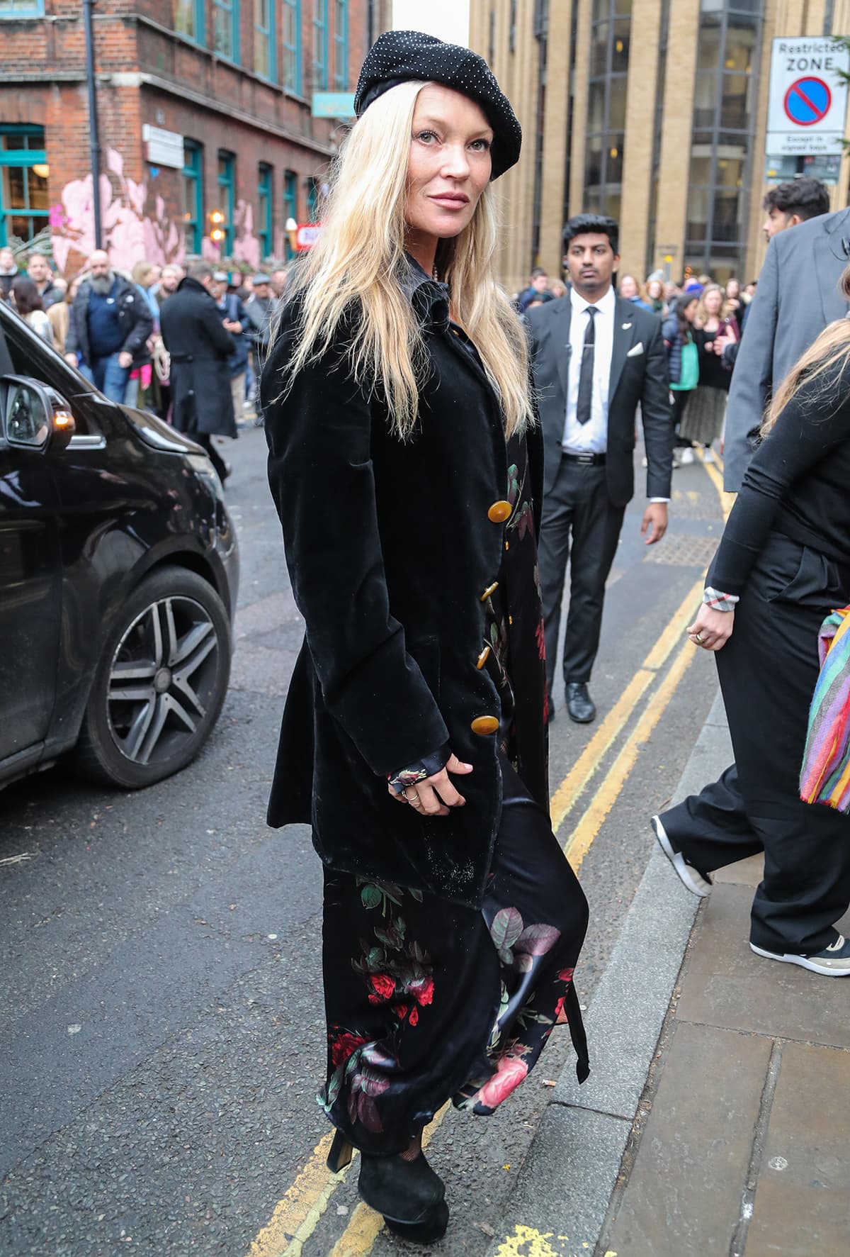 Kate Moss honors Vivienne Westwood in a black floral dress, a velvet coat, and platform heels