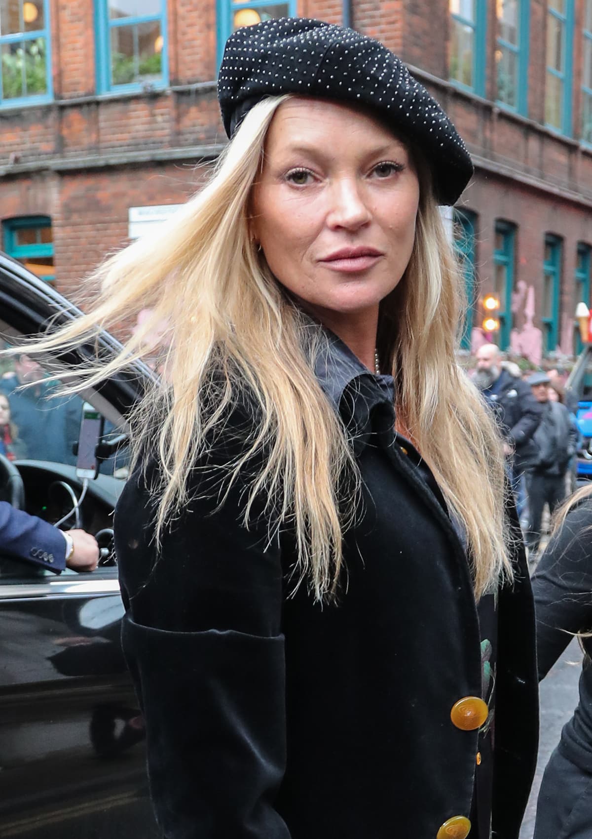 Kate Moss opts for a no-makeup makeup look as she hides her blonde tresses underneath a crystal-studded beret