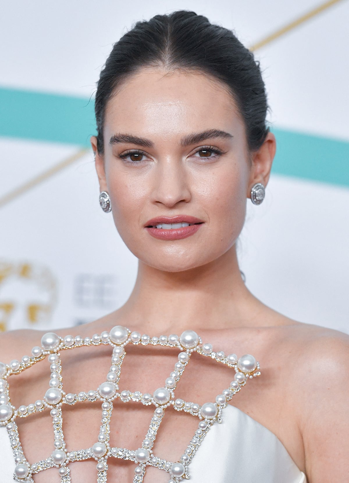 Lily James looks glowing with Charlotte Tilbury makeup and with her tresses in a sophisticated bun