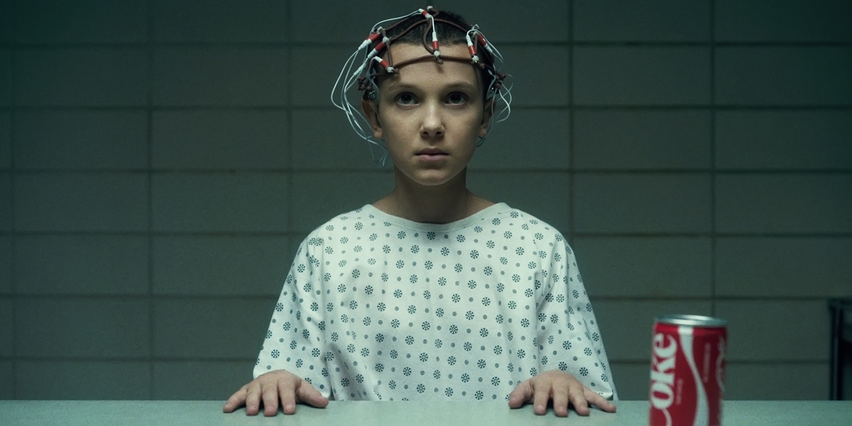 In Stranger Things, Eleven is a girl born with psychokinetic and telepathic powers whose experiments with alternate dimensions lead to her opening a gateway to the Upside Down; her powers are inherited from her mother, a test subject for Project MKUltra, a real-world CIA program that used drugs, electro-shock therapy, and sensory deprivation to control the human mind during the Cold War, which was officially halted in 1973 with all related files destroyed