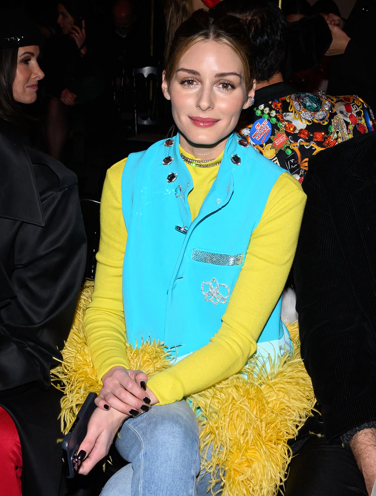 Olivia Palermo teams Georges Hobeika's yellow feather-trimmed turquoise vest with a yellow sweater and casual jeans