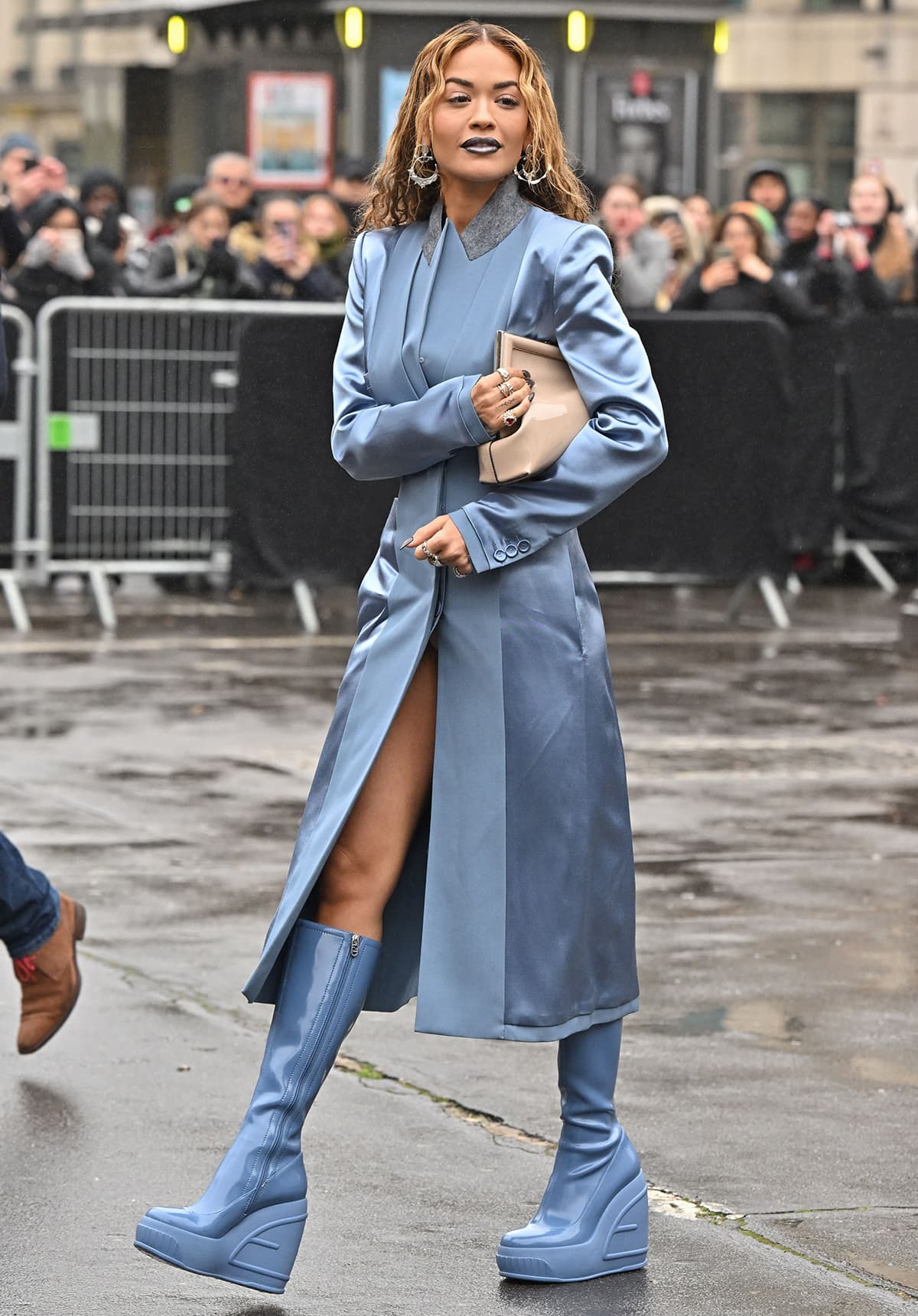 Rita Ora wears a coordinating dusk blue Fendi coat dress, rubber platform boots, and lipstick at the Fendi Haute Couture fashion show during Paris Fashion Week on January 26, 2023